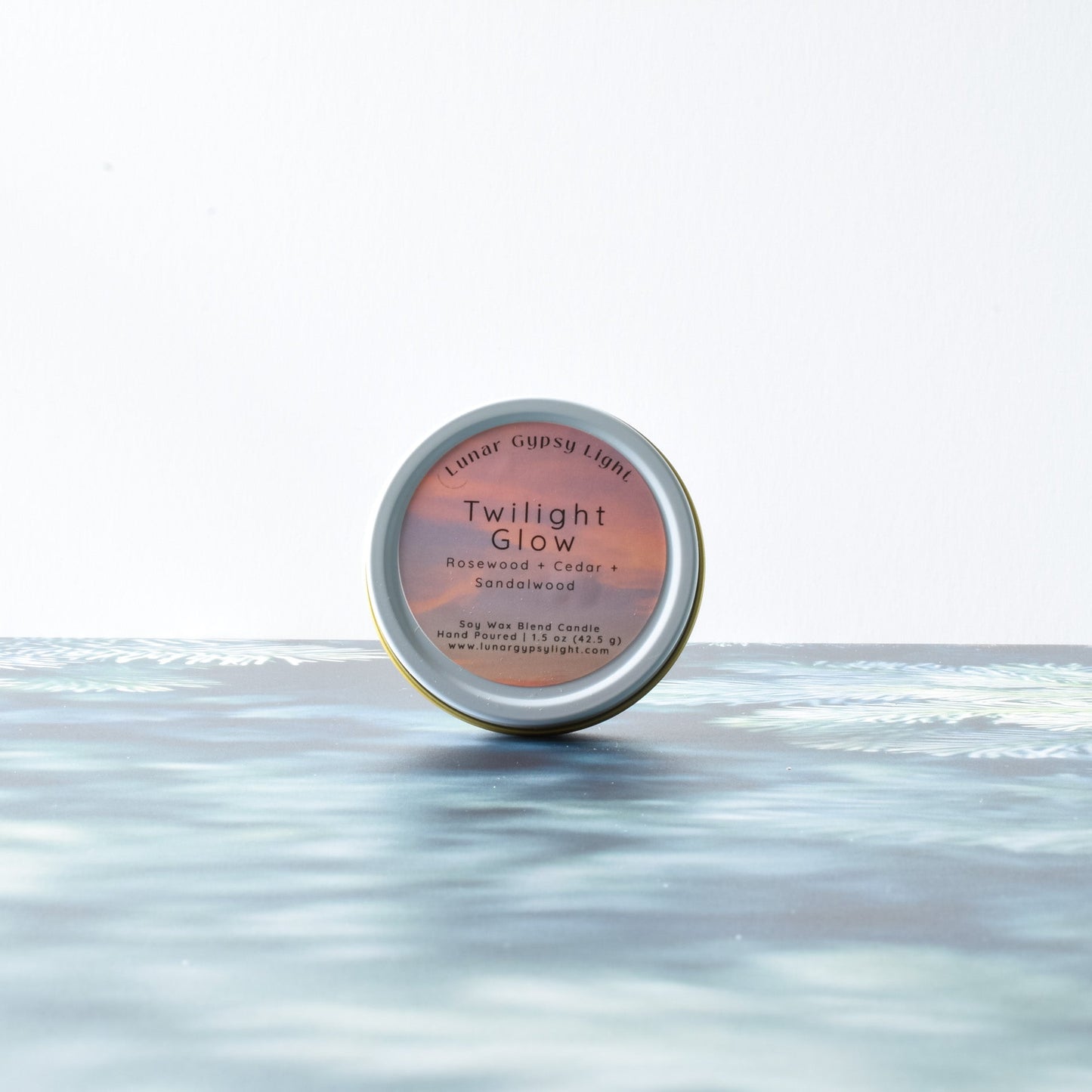 Candle Tin labeled 'Twilight Glow' on a fir inspired surface with a white background