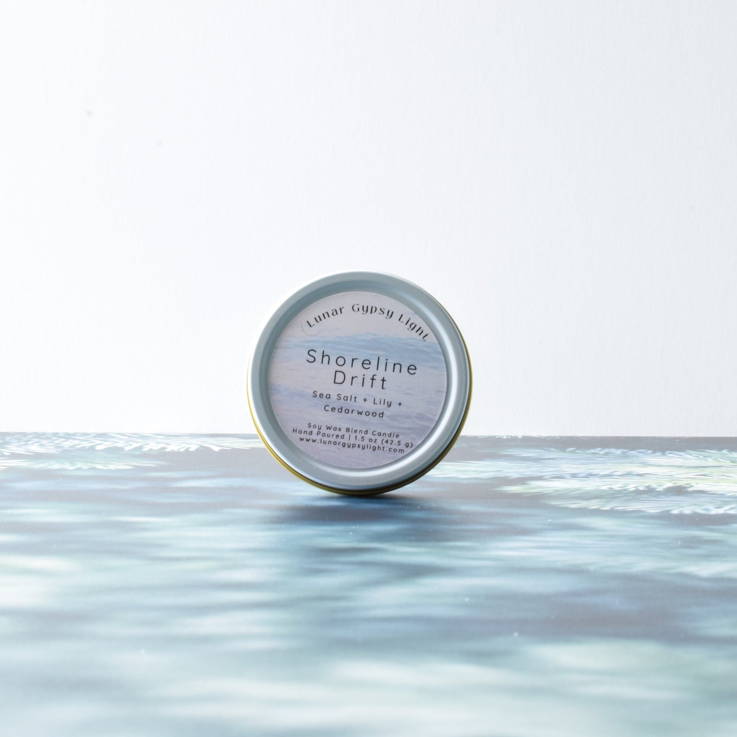 Candle Tin labeled 'Shoreline Drift' on a fir Inspired surface with a white background