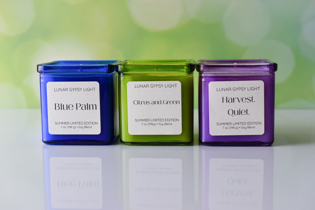 Blue, green, violoet candles with a colorful backdrop of greens. 3 labels that read Blue Palm, Citrus and Green, Harvest Quiet
