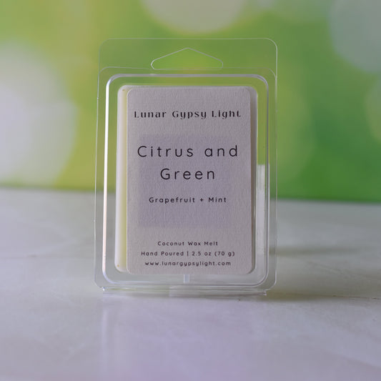 Lunar Gypsy Light Citrus and Green wax melt packaging on a white surface with a blurred green background