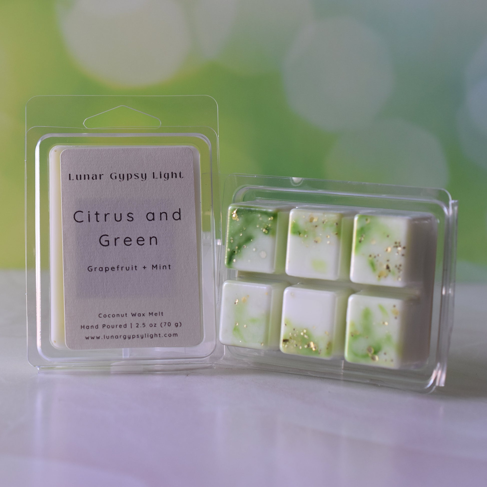 Packaged wax melt that says Citrus and Green on a shell like surface and blurred green and yellow background