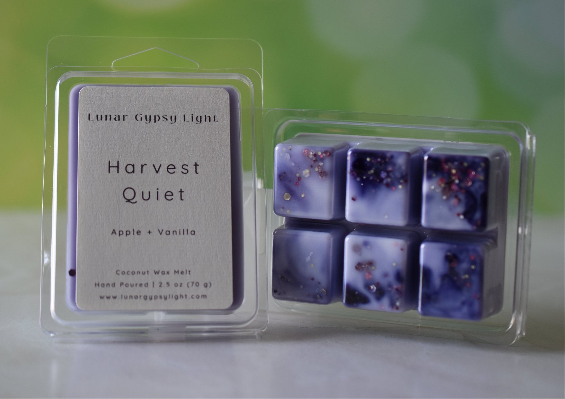 Packaged wax melts with 'Harvest Quiet' label on a blurred green and yellow background