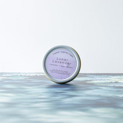 Lunar Lavender small candle tin product on a fir inspired surface with a white background