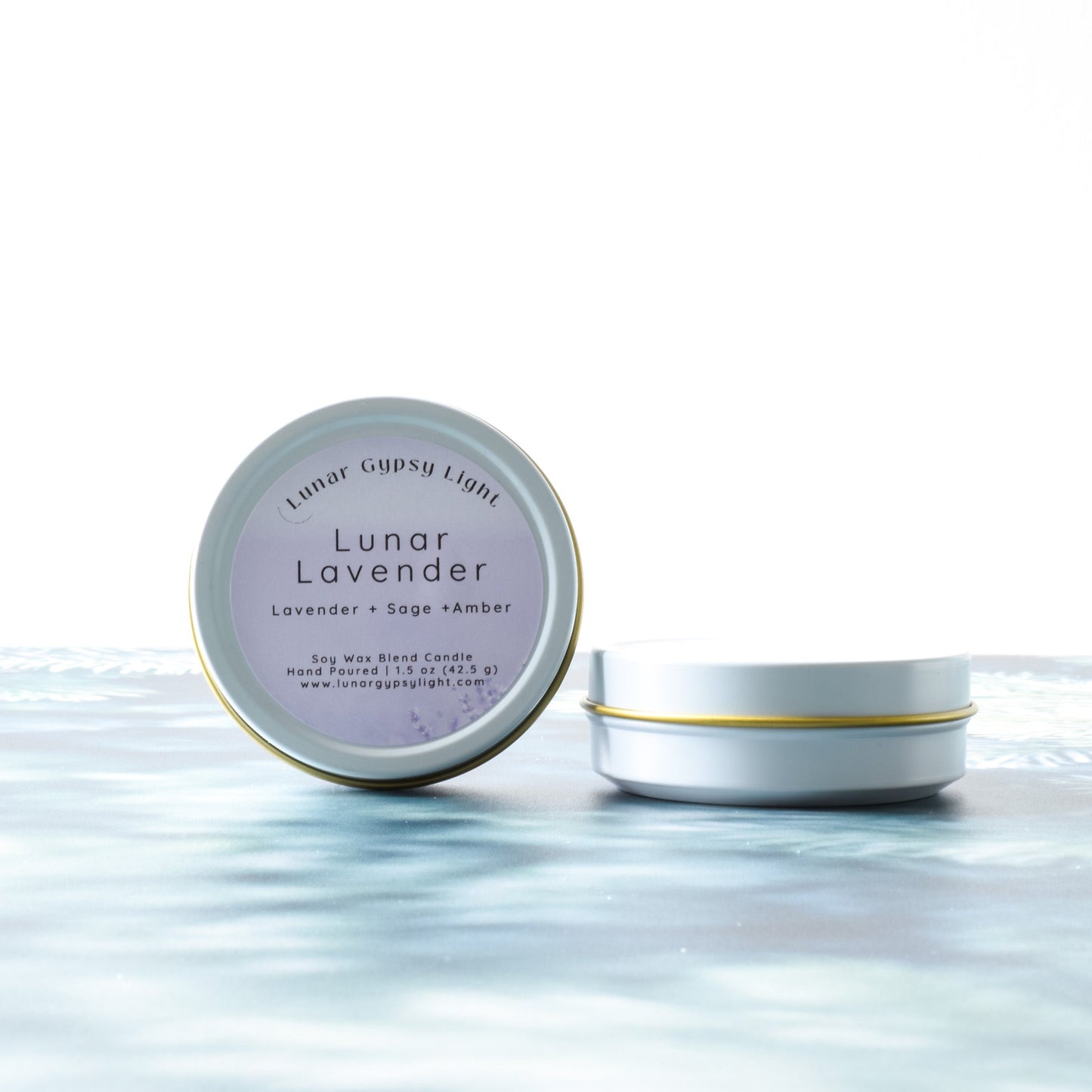 Candle tin Labeled Lunar Lavender candle on a white background and fir inspired surface