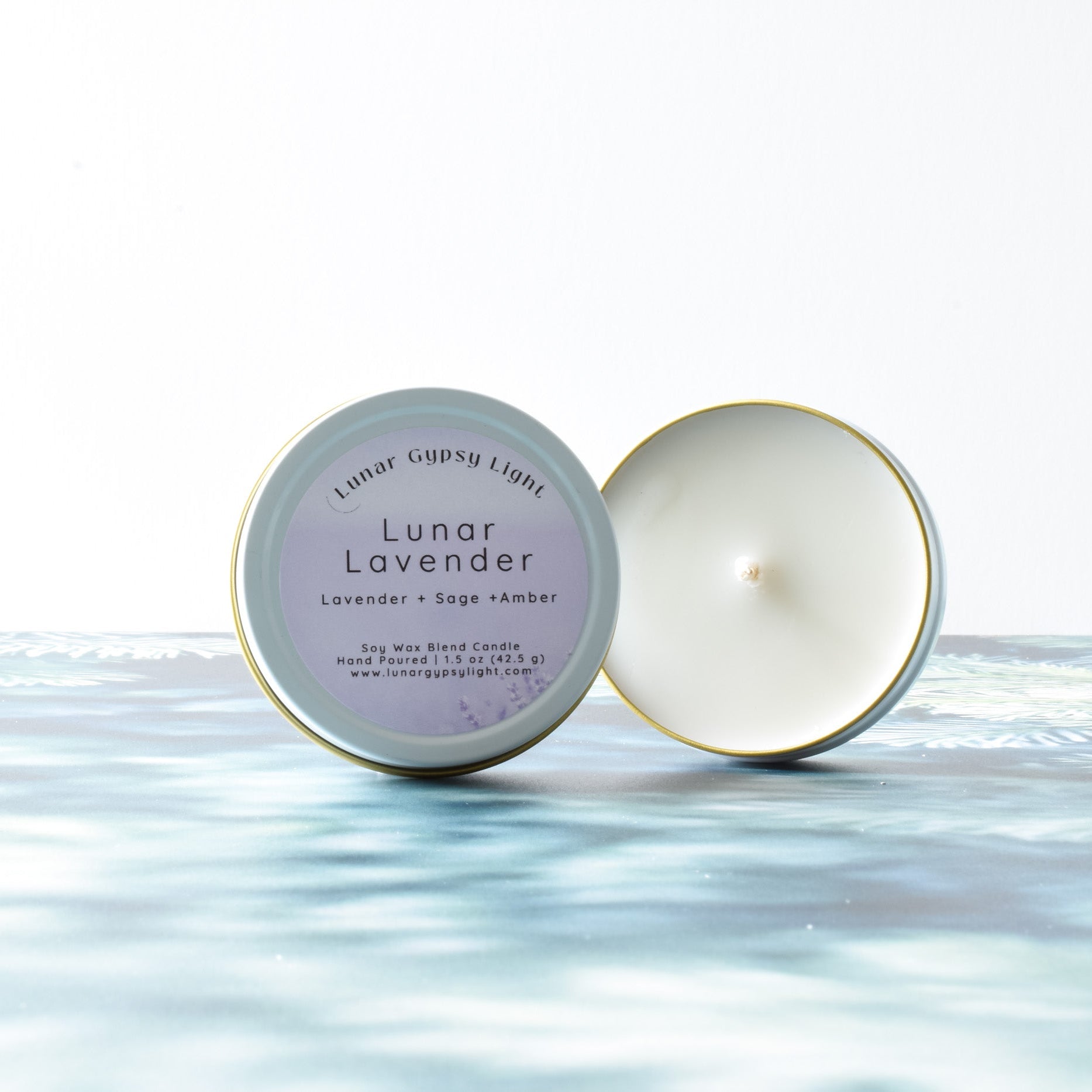 Lunar Lavender mini tin  candle with packaging on a fir inspired surface with white background
