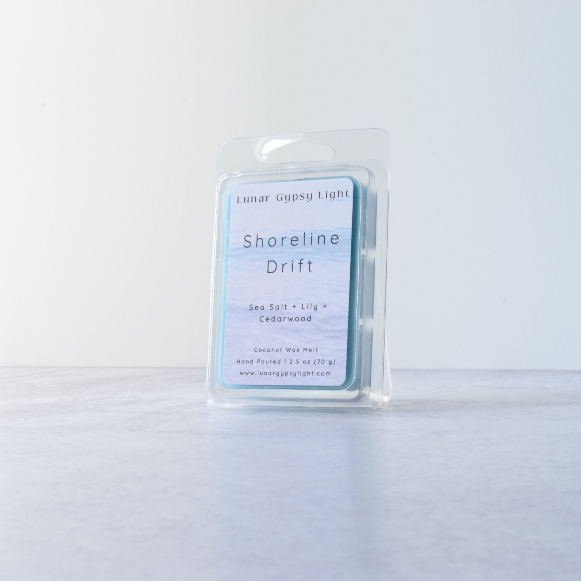 Wax melt in a clear container with a label "Shoreline Drift" on a white background