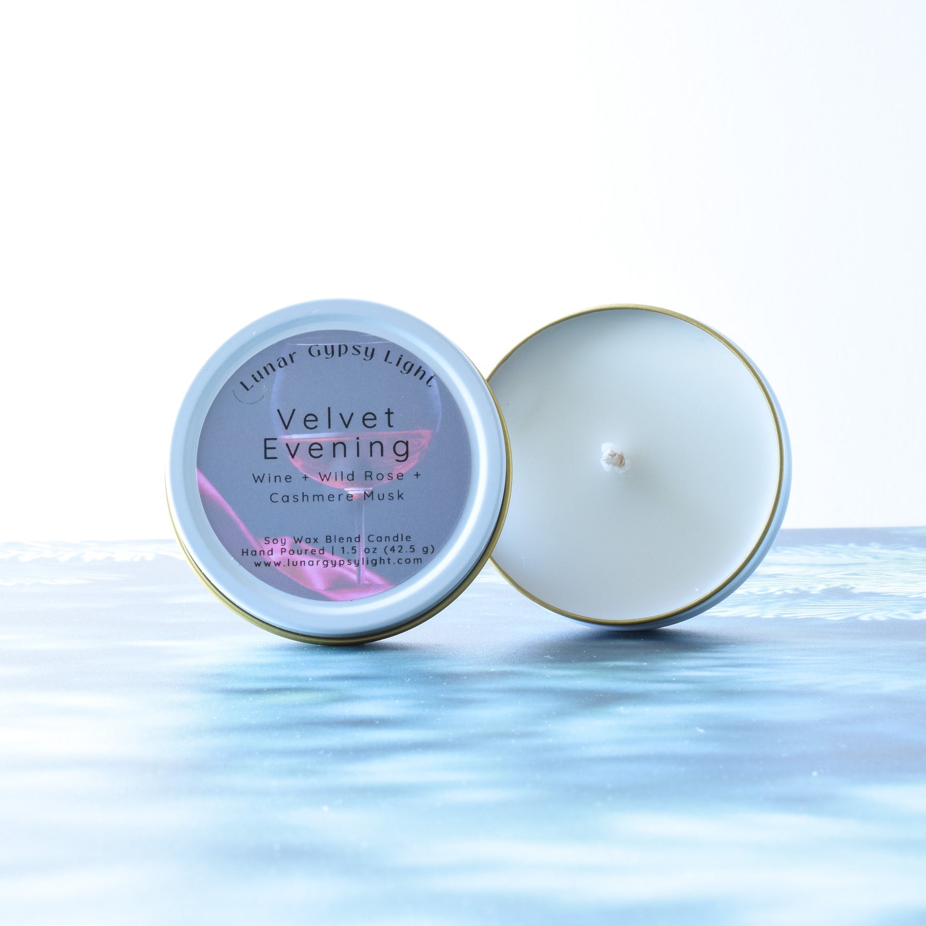 Mini Tin candle, labeled 'Velvet Evening', on a fir inspired surface with a white background.