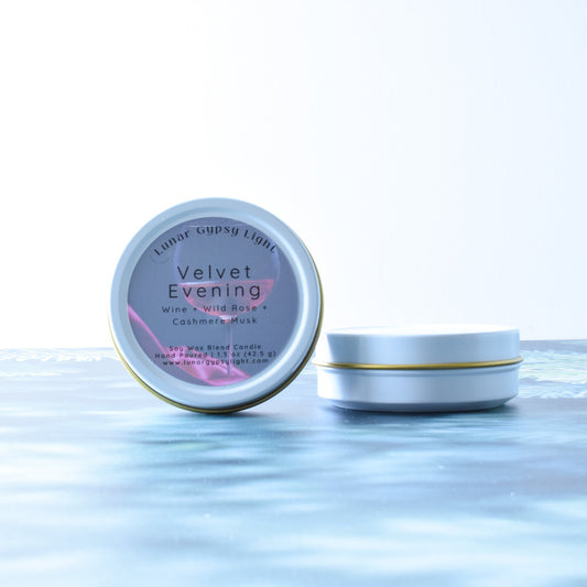 Mini Tin candle, labeled 'Velvet Evening', on a fir inspired surface with a white background.
