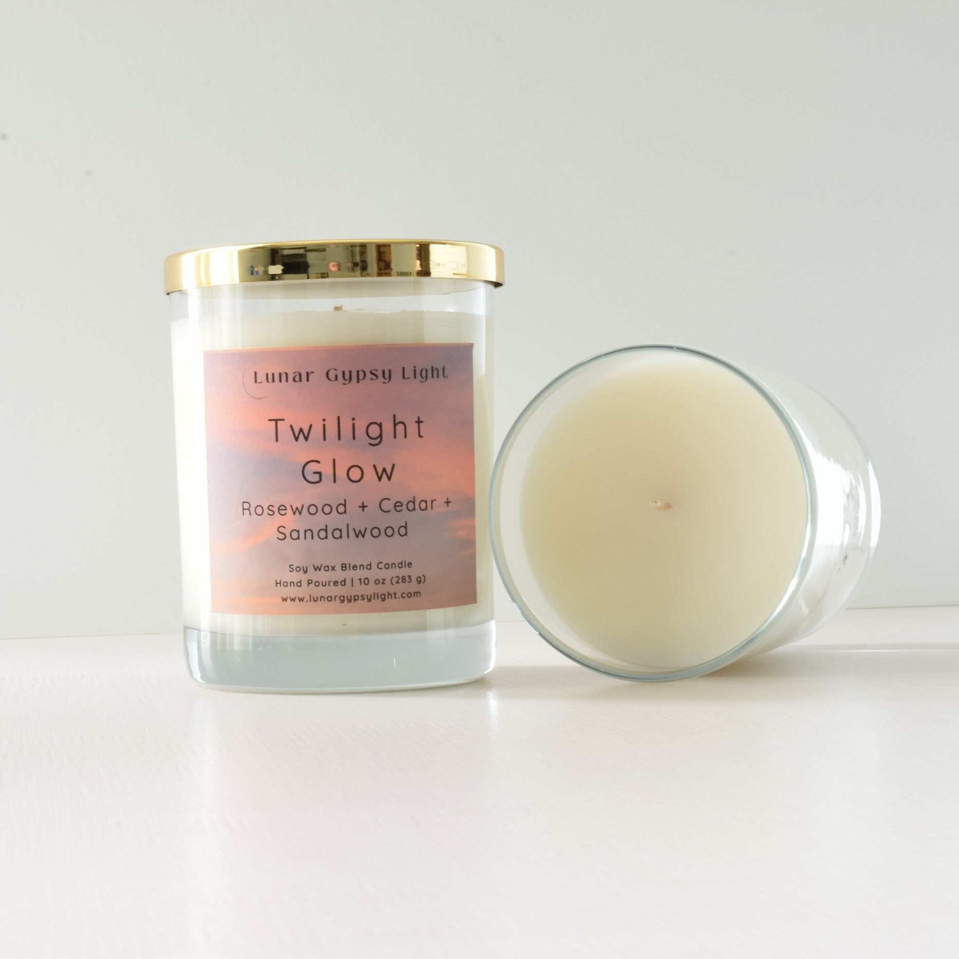 Candle labeled 'Twilight Glow' with a gold lid on a white background