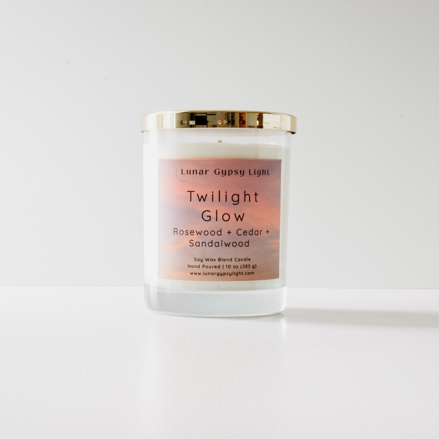 Candle labeled 'Twilight Glow' with a gradient label on a white background and gold lid