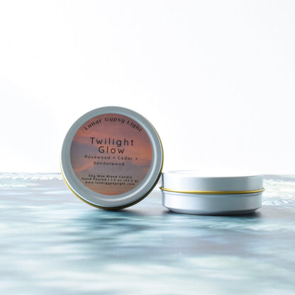 Mini candle tins of 'Twilight Glow' on a fir isnpired surface with a white background