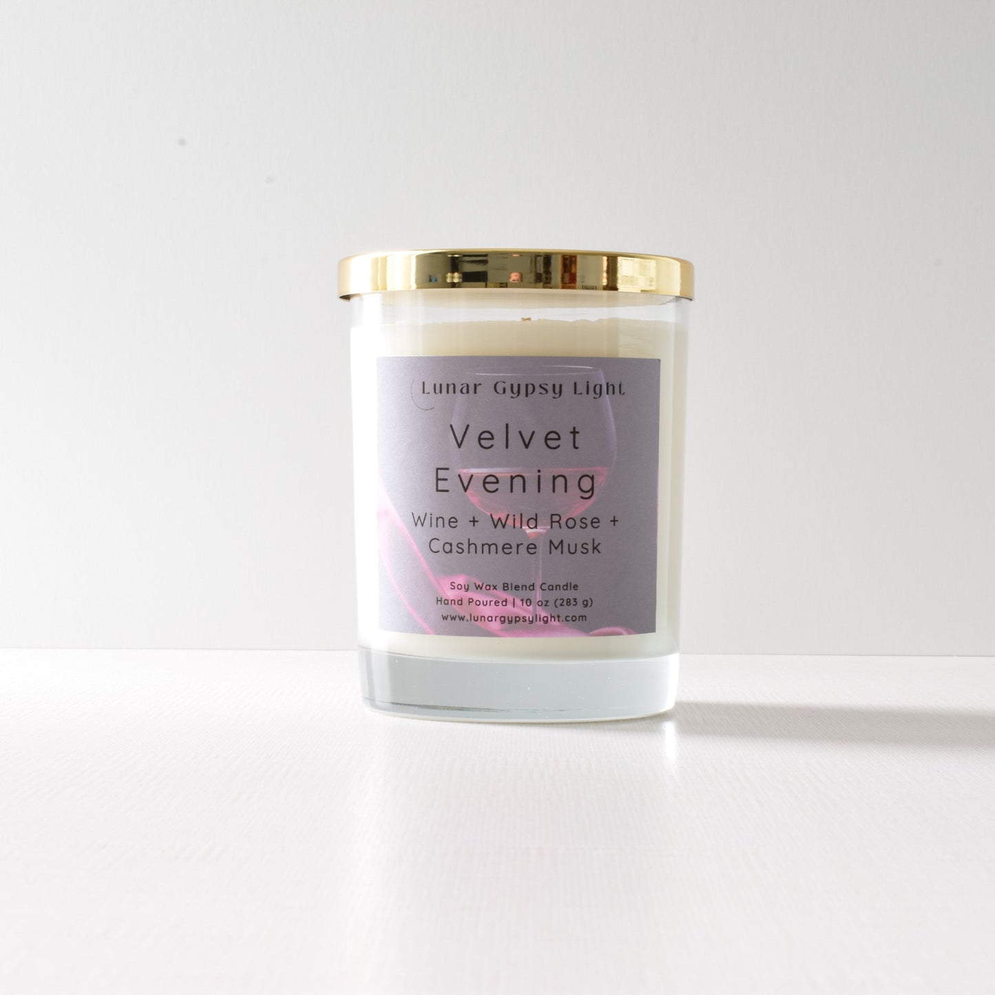 Candle jar labeled 'Velvet Evening' on a white background with gold lid